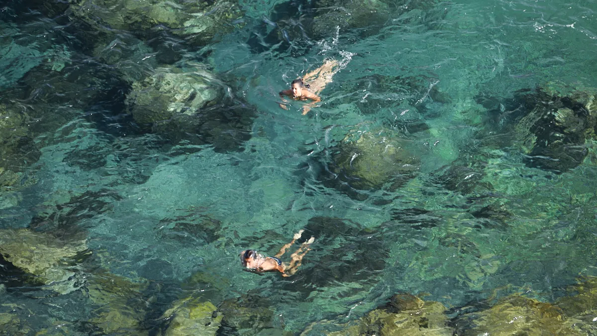 Konservatives Spektrum RKM740 Viszeralchirurgie Düsseldorf Zwei Schwimmer im klaren, türkisfarbenen Wasser – ein Bild für Leichtigkeit, natürliche Regeneration und heilende Prozesse im RKM740 Viszeralchirurgie Düsseldorf.